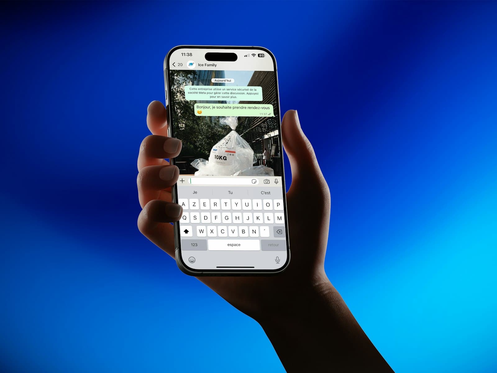 Mano sosteniendo un teléfono con un chat de WhatsApp abierto